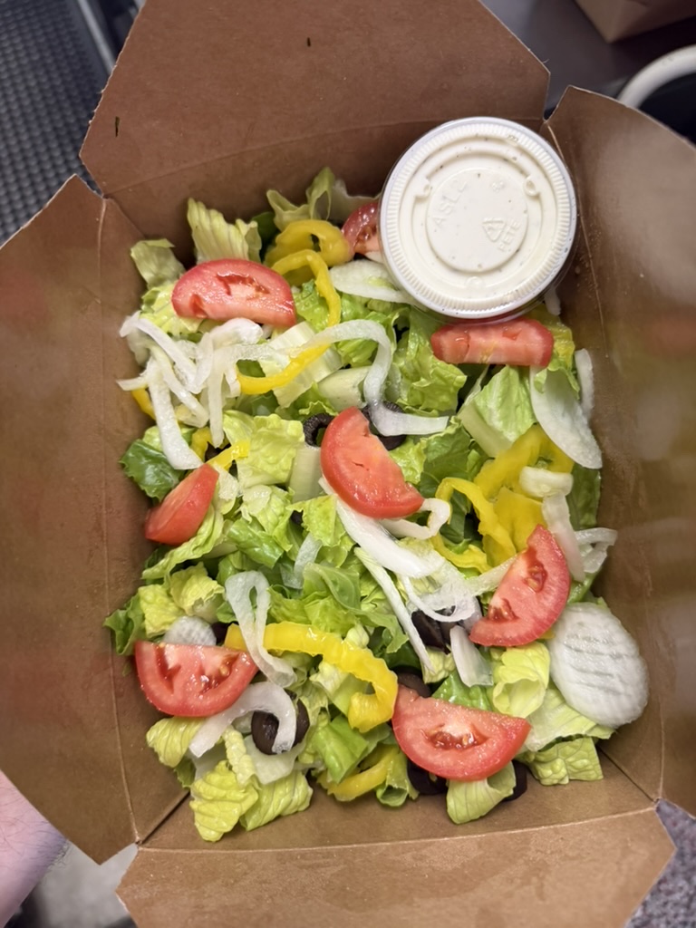 Tossed salad with onion, tomato, banana pepper, black olive, and ranch on the side